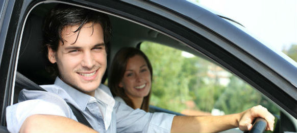 cheerful couple driving in a hire car