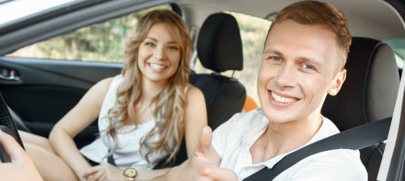 good looking couple posing inside their car