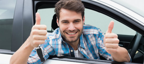 cool guy giving a thumbs up sign while posing inside his car