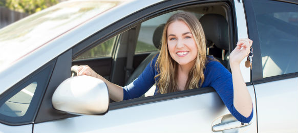 blonde female showing the key of her rental car